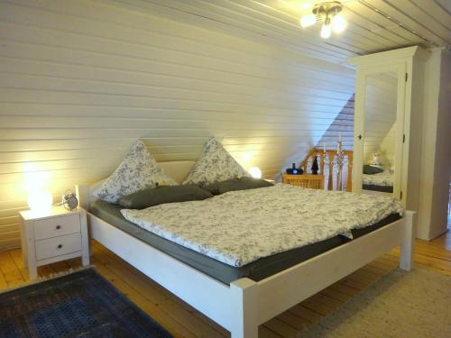 a bedroom with a large bed with a night stand at Ferienhaus Rikate in Kappeln