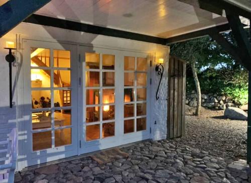 a house with a glass door with a patio at Lille Skov in Rabenkirchen