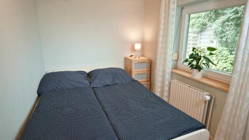 uma cama num quarto com uma janela em Geel Hus em Brodersby
