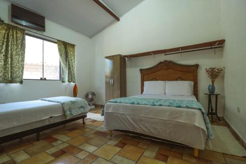 - une chambre avec un grand lit et une fenêtre dans l'établissement Vyzuh Guest House, à Vale do Capão