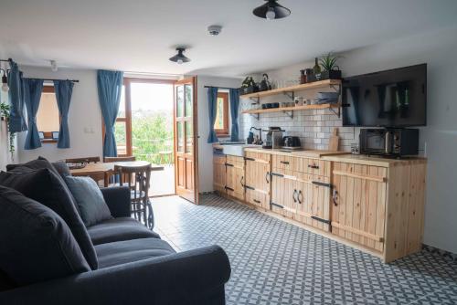 a living room with a couch and a kitchen at EgerCottages - Bikavér Cottage in Eger
