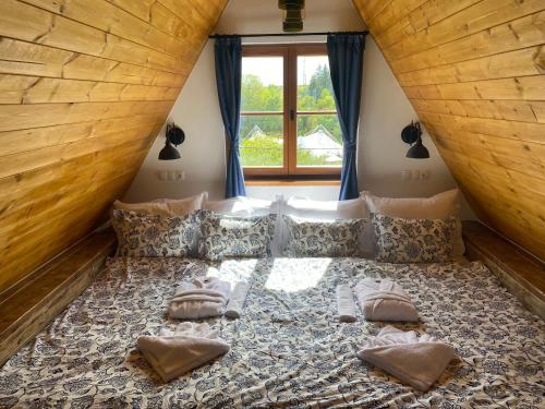 um quarto com uma cama grande e uma janela grande em EgerCottages - Bikavér Cottage em Eger