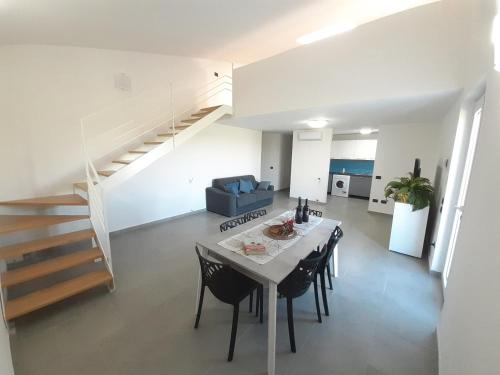 a living room with a table and chairs and a staircase at Campofelice Holidays in Campofelice di Roccella