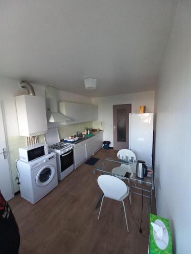 een keuken met witte apparatuur en een tafel en stoelen bij Room in an appartment in montpellier in Montpellier