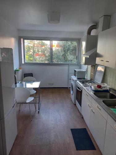 een keuken met witte apparatuur en een tafel en een raam bij Room in an appartment in montpellier in Montpellier