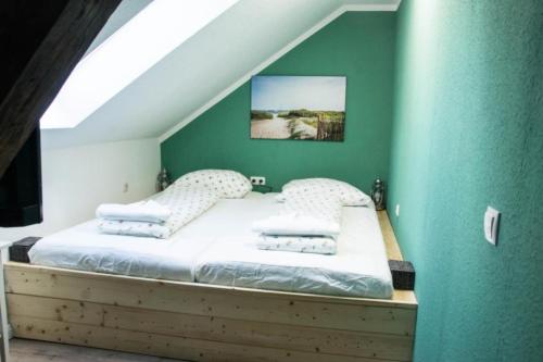 een bed in een kamer met een groene muur bij Meierei 26 in Göhl