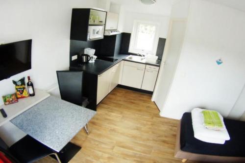 uma pequena cozinha com uma cozinha a preto e branco em "ATHEN " - Studio mit Sandstrand & Seeblick nahe Rhein-Main und Spessart em Kahl am Main