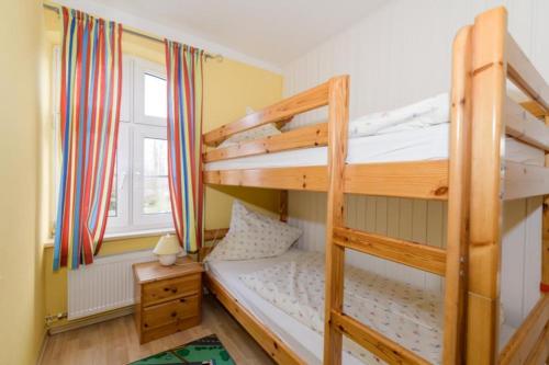 a bedroom with two bunk beds and a window at FerienGut Gaarz - Kavaliershaus 17 in Göhl