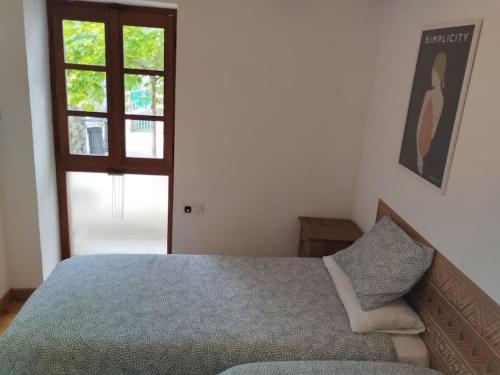 Schlafzimmer mit einem Bett und einem Fenster in der Unterkunft Apartamento centro Benasque in Benasque