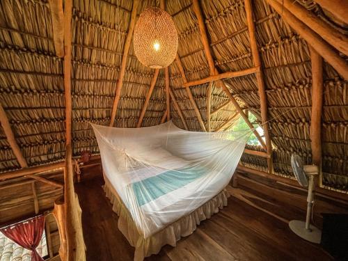 a hammock in a straw hut with a light at Casa La Aventura Guasacate - Popoyo in Salinas