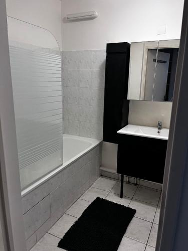 une salle de bain avec une baignoire, un lavabo et une douche dans l'établissement Disney world Appart 10P , 5 min du parc, parking privé, à Chessy