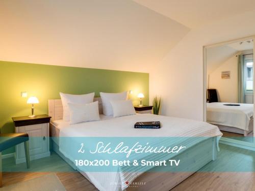 ein Schlafzimmer mit einem großen Bett und einem Spiegel in der Unterkunft Ferienhaus StrandLiebe in Olpenitz