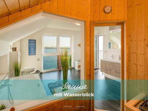 ein großes Bad mit Badewanne und eine Küche in der Unterkunft Ferienhaus StrandLiebe in Olpenitz