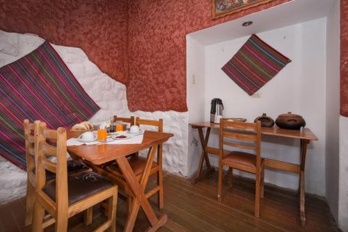 a dining room with a wooden table and chairs at Hotel Guest House Wayra in Cusco