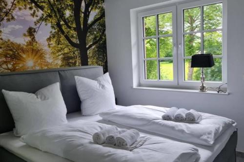 um quarto com 2 camas com toalhas e uma janela em Muehlenblick 3 - Traumferien in Hage em Hage