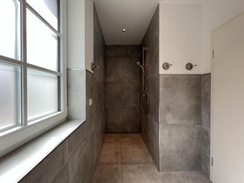 uma casa de banho com um chuveiro e uma janela em Muehlenblick 3 - Traumferien in Hage em Hage