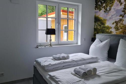 ein Bett mit Handtüchern und einem Fenster in der Unterkunft Mьhlenblick 1 - Luxuswohnung im Luftkurort Hage in Hage