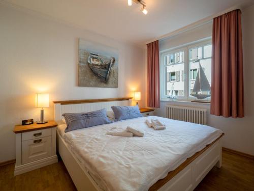 sypialnia z dużym białym łóżkiem i oknem w obiekcie Ferienwohnung 560 in der Villa Gudrun w mieście Binz