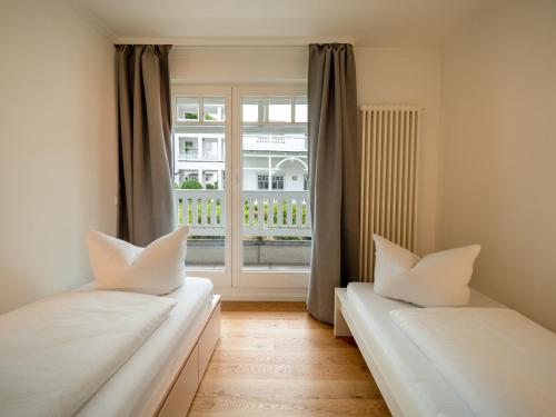 two beds in a room with a window at Ferienwohnung 561 in der Villa Gudrun in Binz