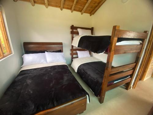 1 dormitorio con 2 literas y escalera en Rancho New Life Guatavita en Guatavita