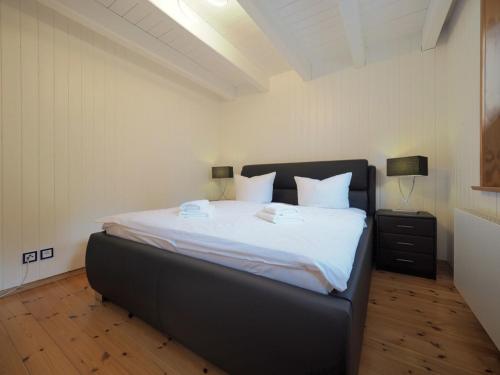 um quarto com uma cama grande e lençóis brancos em Ferienhaus Marie em Binz