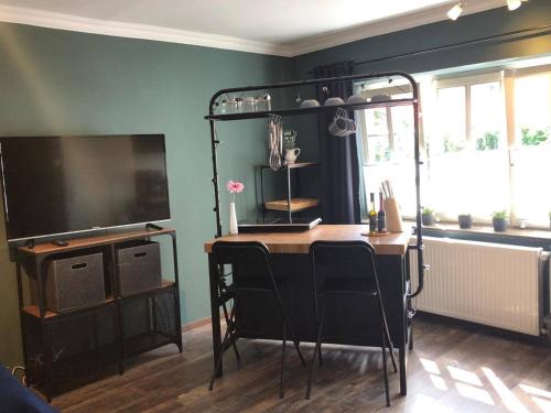 a room with a table with chairs and a television at Wohnung 5 in Fedderwardersiel