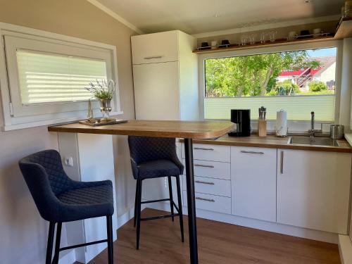 a kitchen with a counter and two bar stools at Tiny House Max in Fedderwardersiel