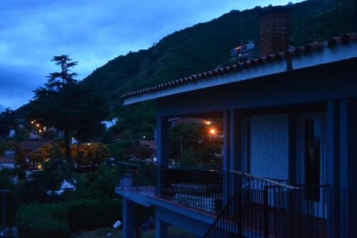 a house with a balcony with a mountain in the background at Casa Alta Hotel Boutique & Spa - Solo Adultos in Villa Carlos Paz
