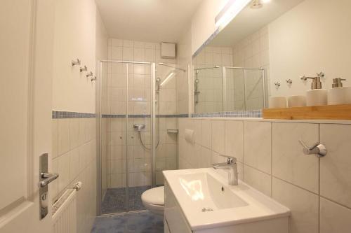a bathroom with a shower and a sink and a toilet at Landhaus am Ufer - Wohnung 3 in Heiligenhafen