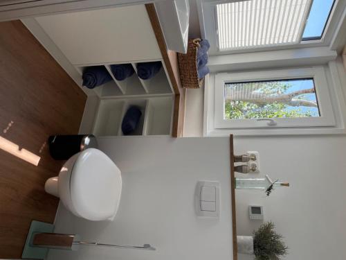 una nevera blanca en una cocina con ventana en Tiny House Moritz en Fedderwardersiel