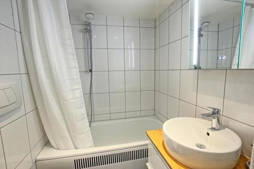 a white bathroom with a sink and a shower at Haus am Binnensee in Heiligenhafen