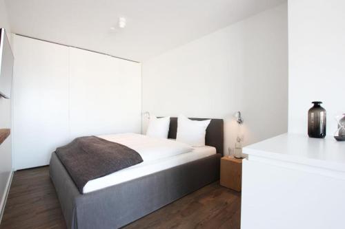 a bedroom with a large bed with white walls at Strandzeit Heiligenhafen in Heiligenhafen