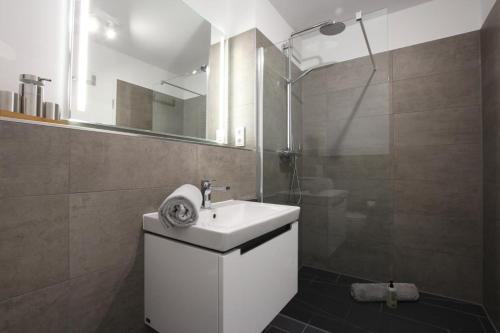 a bathroom with a white sink and a shower at Strandzeit Heiligenhafen in Heiligenhafen