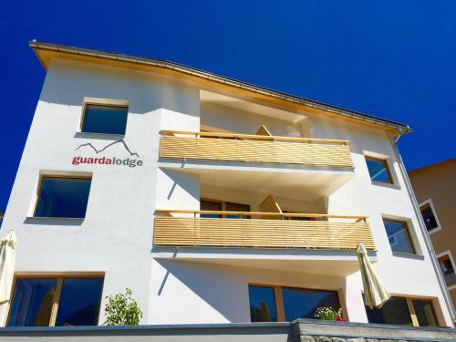 a white building with a balcony on the side at Guarda Lodge in Guarda