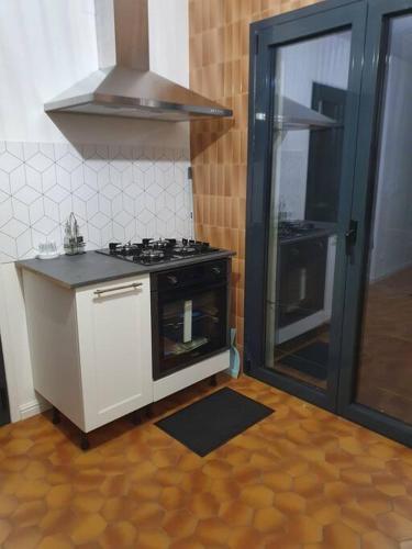 une cuisine avec une cuisinière et un comptoir dans l'établissement Appartement F3 meublé et équipé, à Saint-Cyprien