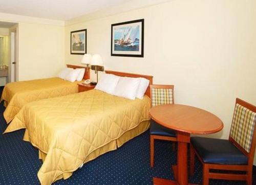 a hotel room with two beds and a table at Hatteras Island Inn in Buxton