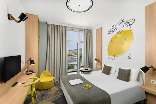 a hotel room with a bed and a desk and a room at Ibis Styles Budapest City in Budapest