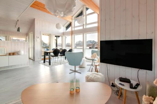 a living room with a tv and a table at Vaeranes- Ny hytte med flott utsikt in Ramberg
