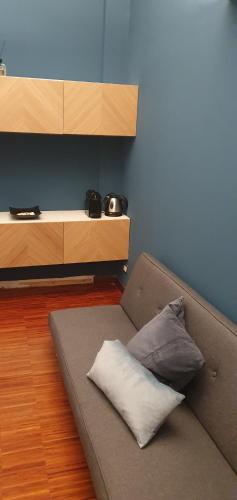 Gaia Suites في تورينو: أريكة مع وسادة على الأرض في غرفة
