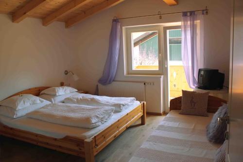 ein Schlafzimmer mit einem Holzbett und einem Fenster in der Unterkunft Haus Senoner in Kitzbühel