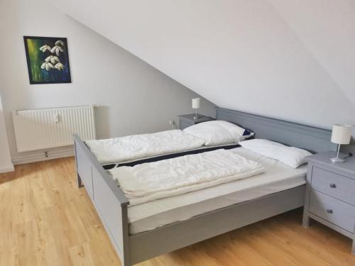 een bed in een kamer met een witte muur bij Apartmentvermittlung Mehr als Meer - Objekt 74 in Niendorf