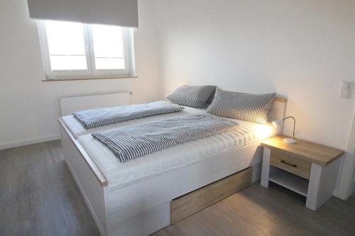 Bett in einem Zimmer mit einer Lampe auf einem Tisch in der Unterkunft Appartementvermittlung Mehr als Meer Objekt 50 in Timmendorfer Strand