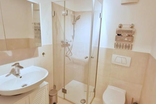 La salle de bains est pourvue d'une douche, d'un lavabo et de toilettes. dans l'établissement Apartmentvermittlung Mehr als Meer - Objekt 26, à Timmendorfer Strand