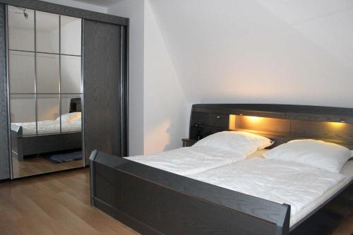 a bedroom with a large bed and a mirror at Apartmentvermittlung Mehr als Meer - Objekt 54 in Niendorf