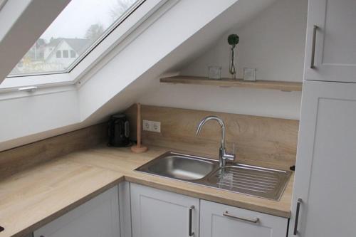 a kitchen with a sink and a window at Apartmentvermittlung Mehr als Meer - Objekt 24 in Niendorf