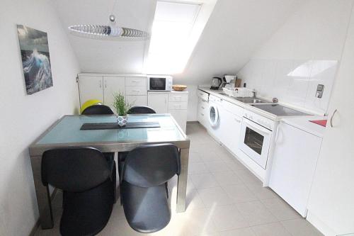 a kitchen with a table and chairs and a sink at Apartmentvermittlung Mehr als Meer - Objekt 8 in Niendorf