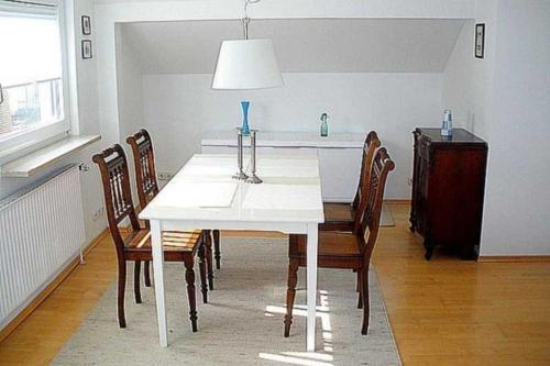 a dining room with a white table and chairs at Apartmentvermittlung Mehr als Meer - Objekt 28 in Niendorf