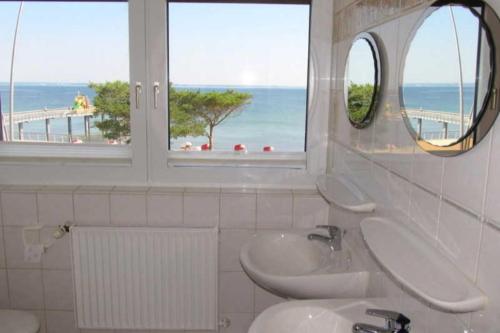 a bathroom with two sinks and a view of the beach at Apartmentvermittlung Mehr als Meer - Objekt 28 in Niendorf