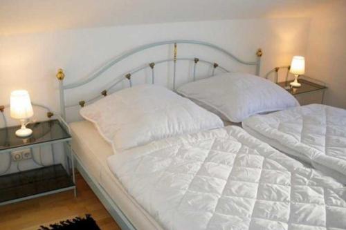 a bedroom with two beds with white sheets and two lamps at Apartmentvermittlung Mehr als Meer - Objekt 28 in Niendorf