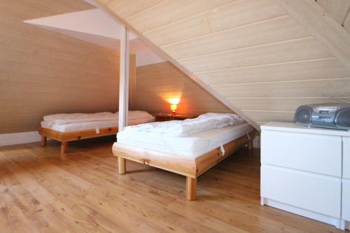 a attic room with two beds and a table at Apartmentvermittlung Mehr als Meer - Objekt 41 in Niendorf